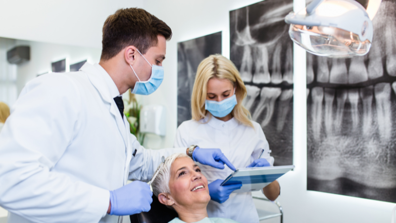 Photographie d'une assistante dentaire et d'un dentiste soignant une patiente